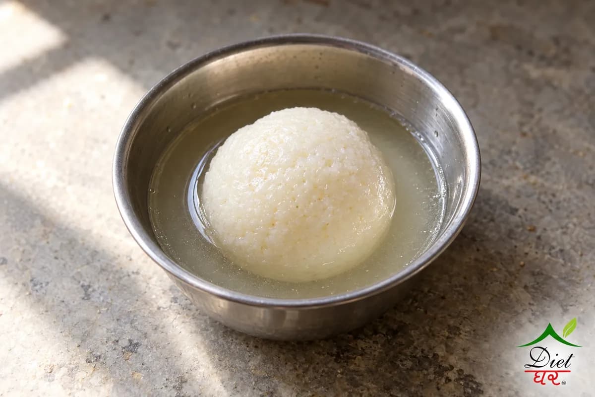One white rasgulla in light sugar syrup in a small bowl
