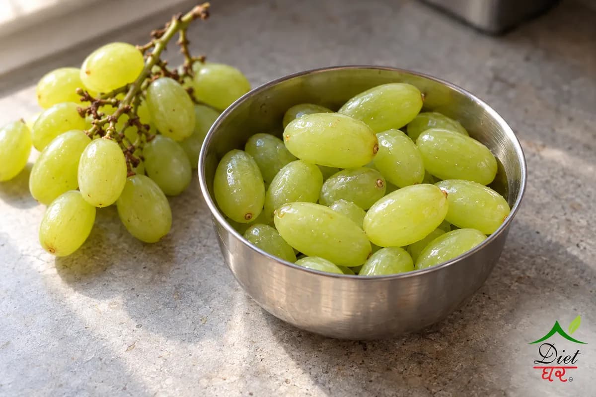 Green grapes in a steel katori beside a small bunch